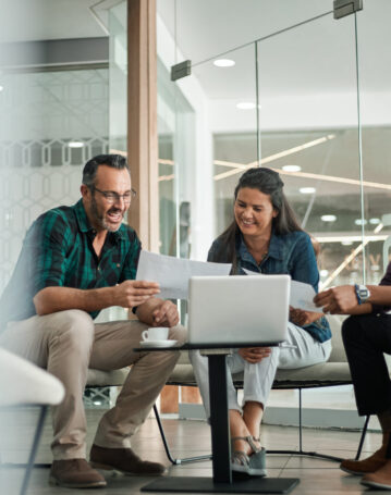 Casual meeting of smiling diverse business team analyzing financial data